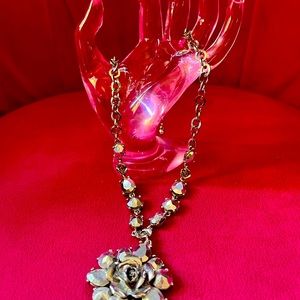 Silver and crystal necklace with flower pendant.